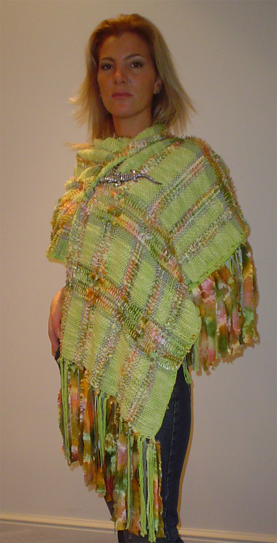Poncho tejido en lana color verde combinada con tonalidades en rosas y  naranjas
